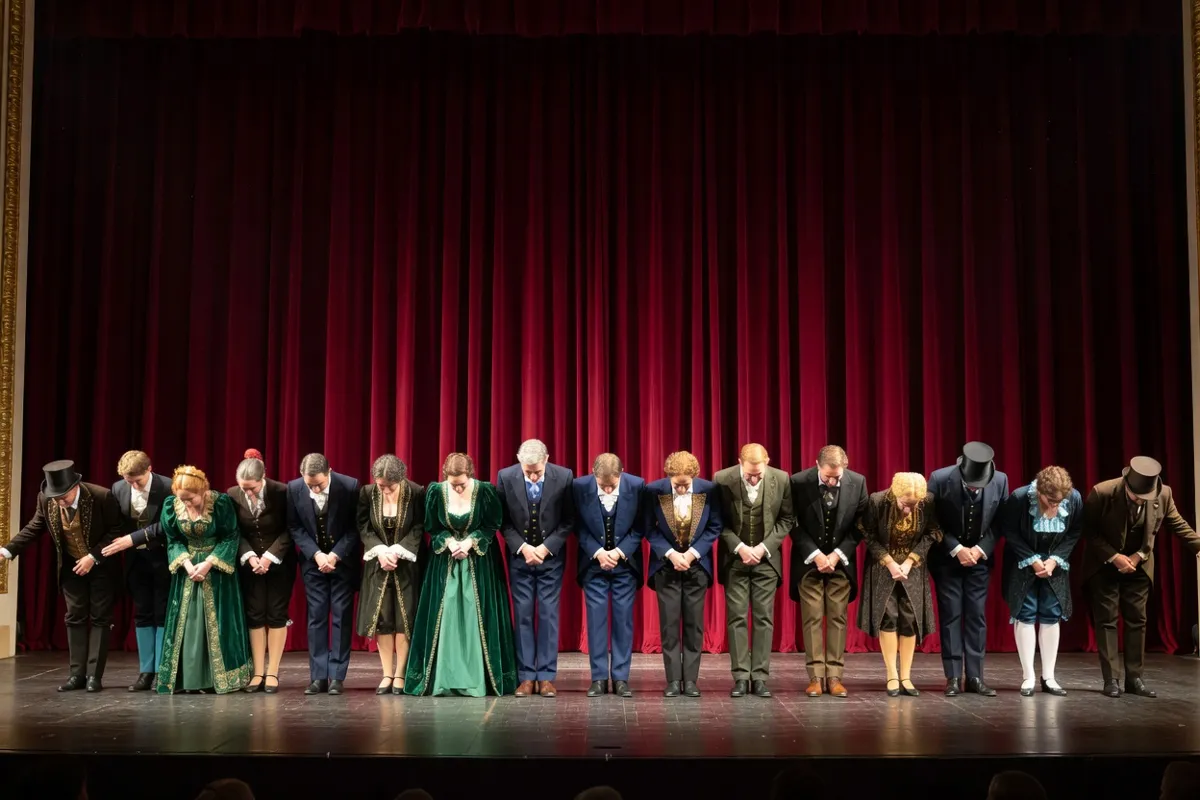 Comédiens en costumes saluant devant un rideau rouge sur une scène de théâtre