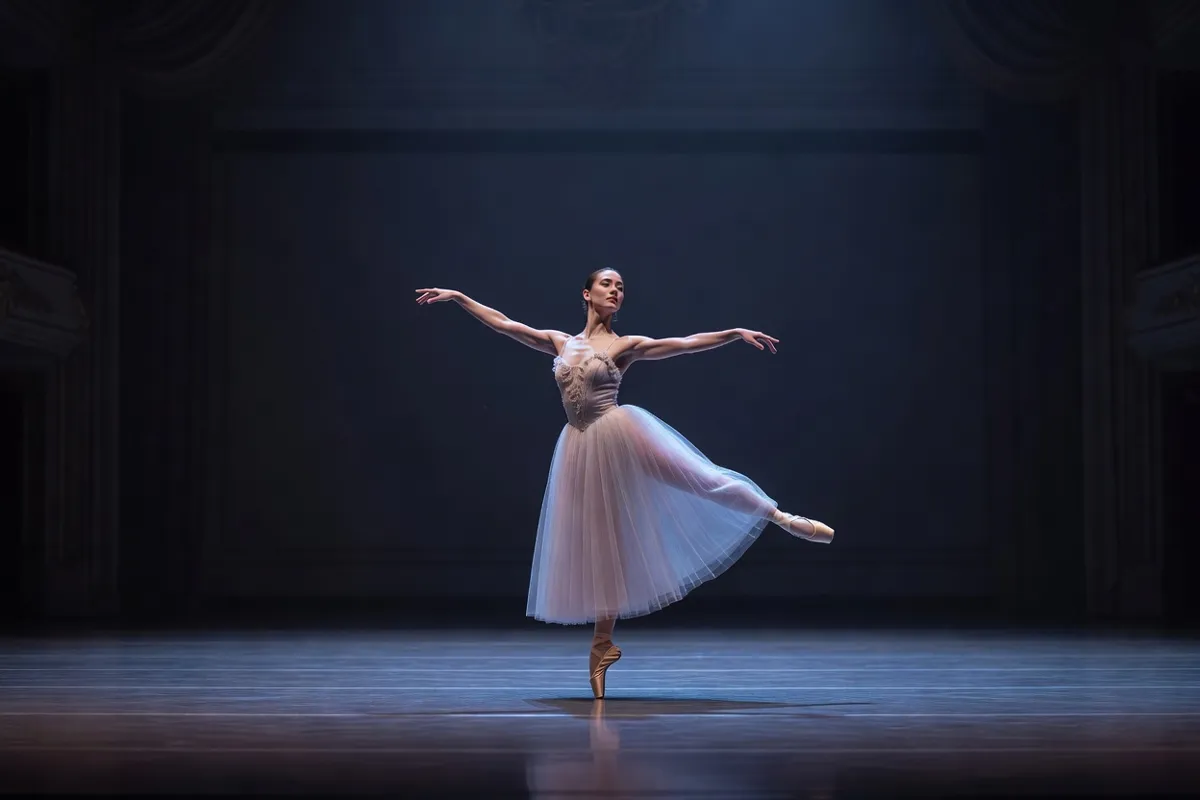 Danseuse en tutu romantique sur une scène de théâtre sous une lumière bleutée
